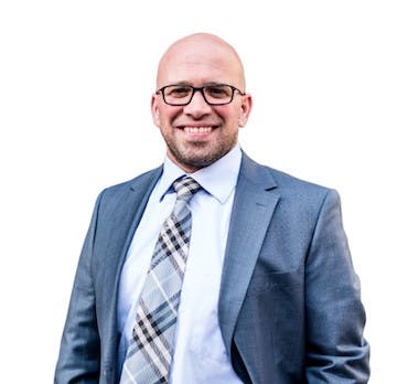 Portrait of Dr. Sam Alfakir, skilled orthodontist, wearing a suit, captured against a white background.