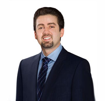 Portrait of Dr. Hugh Saltaji, distinguished orthodontist, dressed in a suit, standing against a white background.